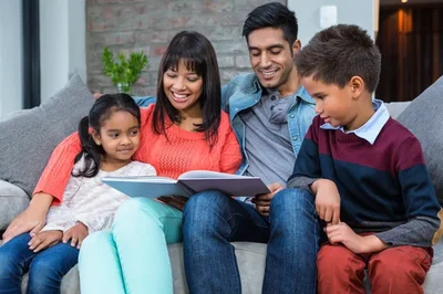 Familia leyendo la Biblia junto a sus hijos